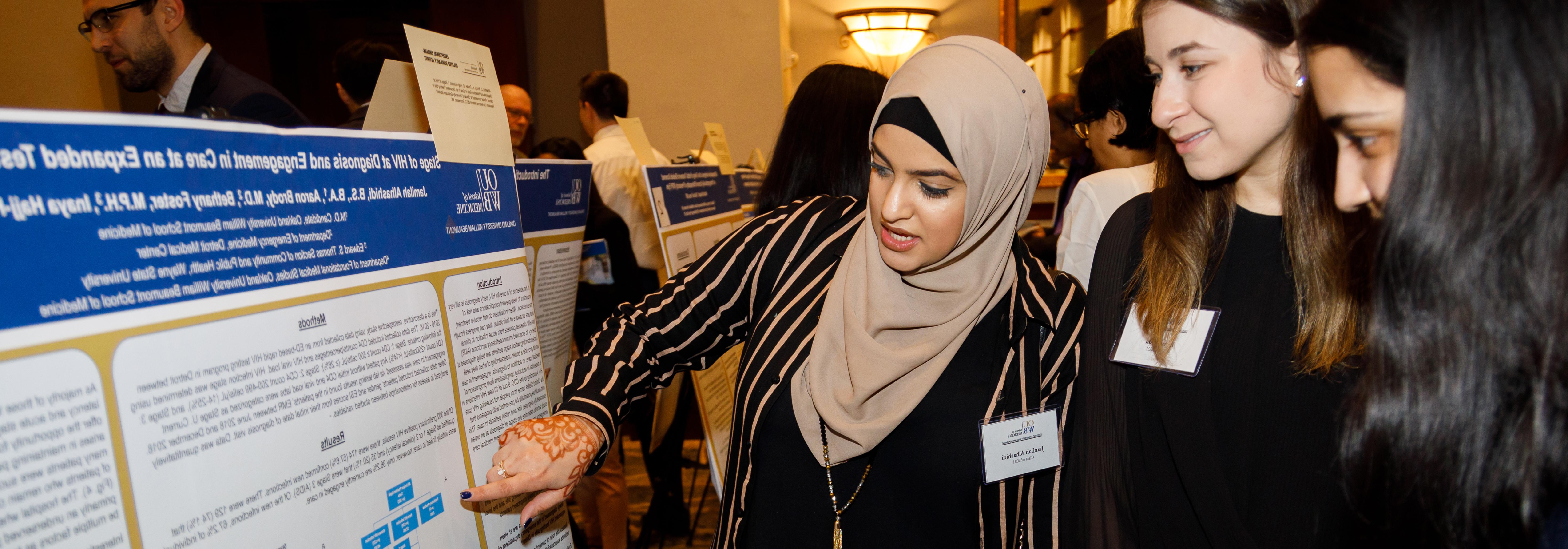 An image of students talking about a poster presentation