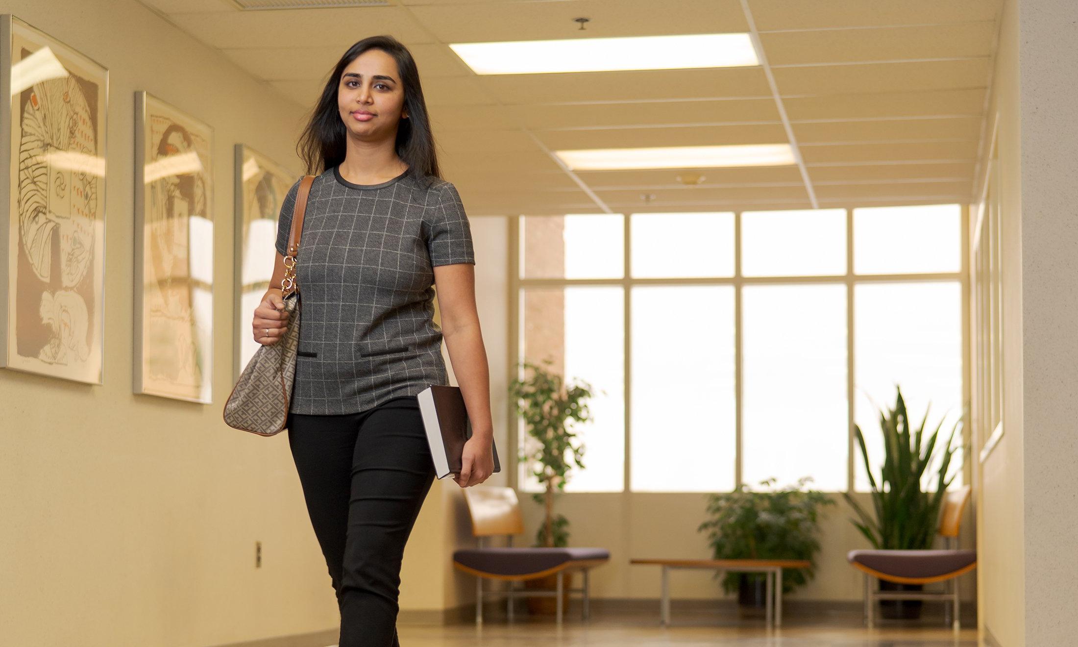 A woman walking down a hallway.